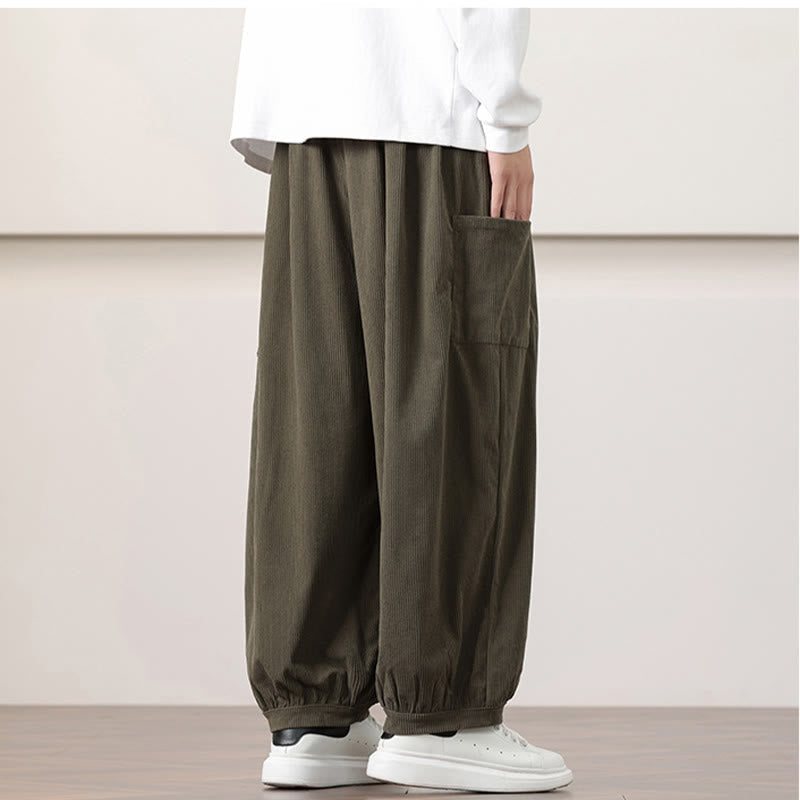 Olive green fine-wale corduroy harem pants featuring roomy side patch pockets and gathered cuffed ankles.
