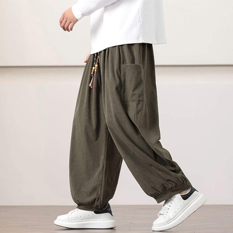 Olive green fine-wale corduroy harem pants with side patch pockets, beaded drawstring waist, and cuffed ankles.