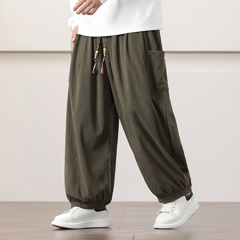 Olive green fine-wale corduroy harem pants with side patch pockets, beaded drawstring waist, and cuffed ankles.