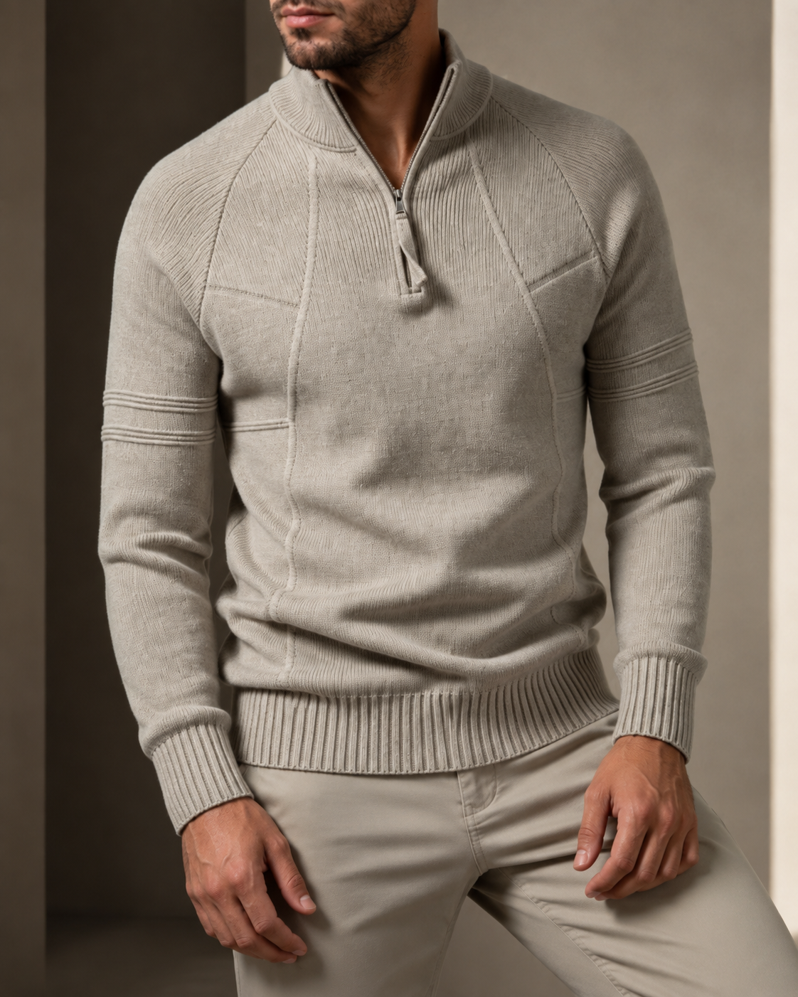 Close-up of beige knit sweater showing the quarter-zip and seamed panel details