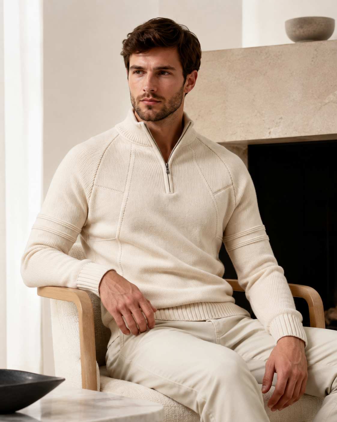Cream quarter-zip knit sweater worn by male model seated indoors