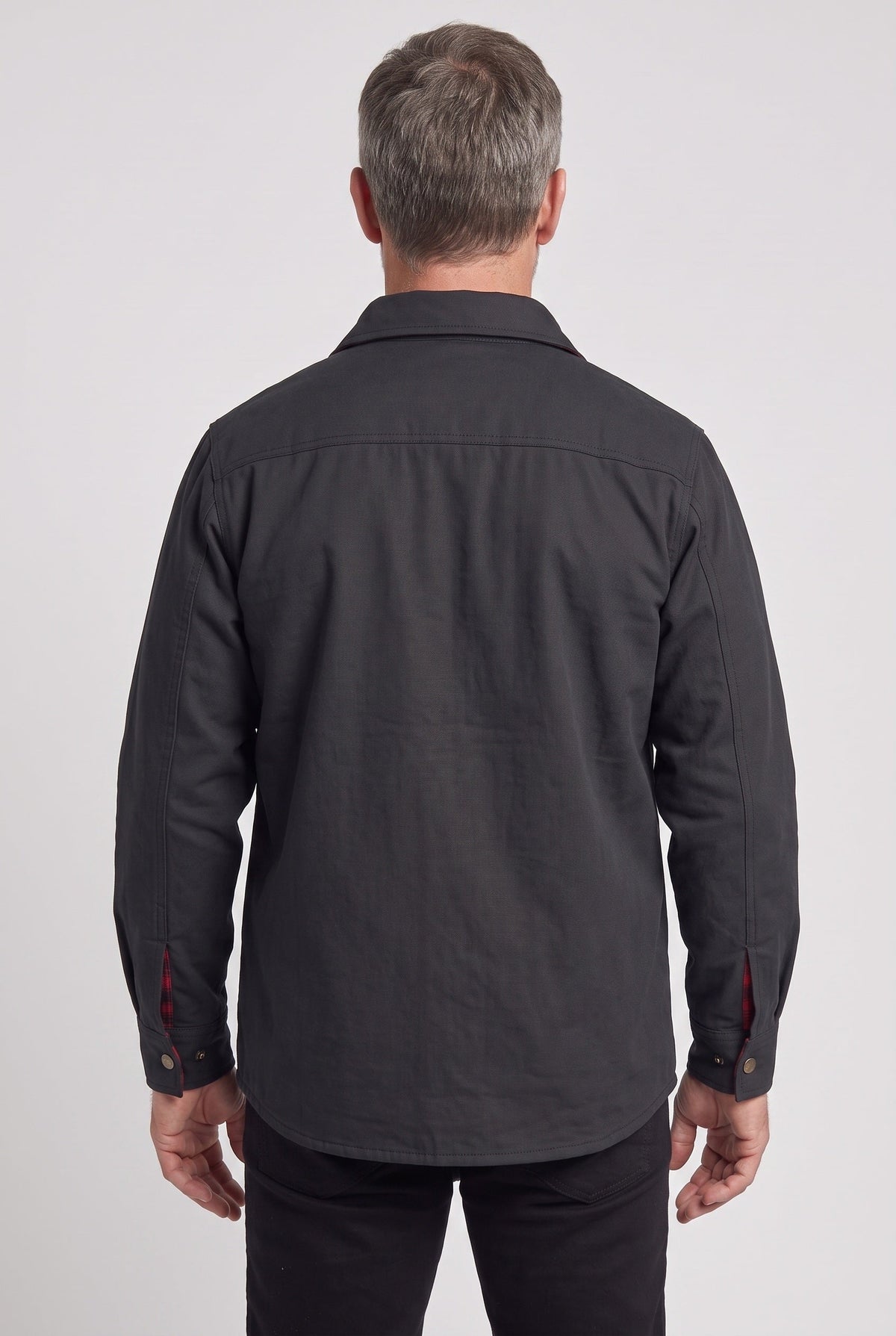 Back view of a model wearing a dark gray or black canvas barn shirt-jacket.
