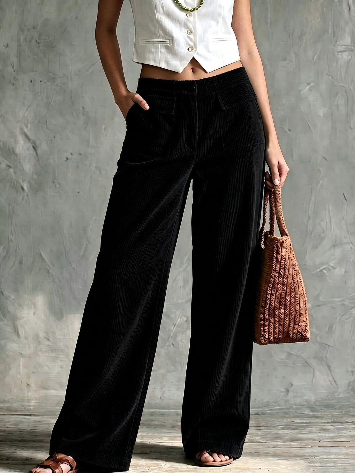 Black fine-wale corduroy wide-leg pants with utility flap pockets and a structured, high-waisted straight-leg silhouette.