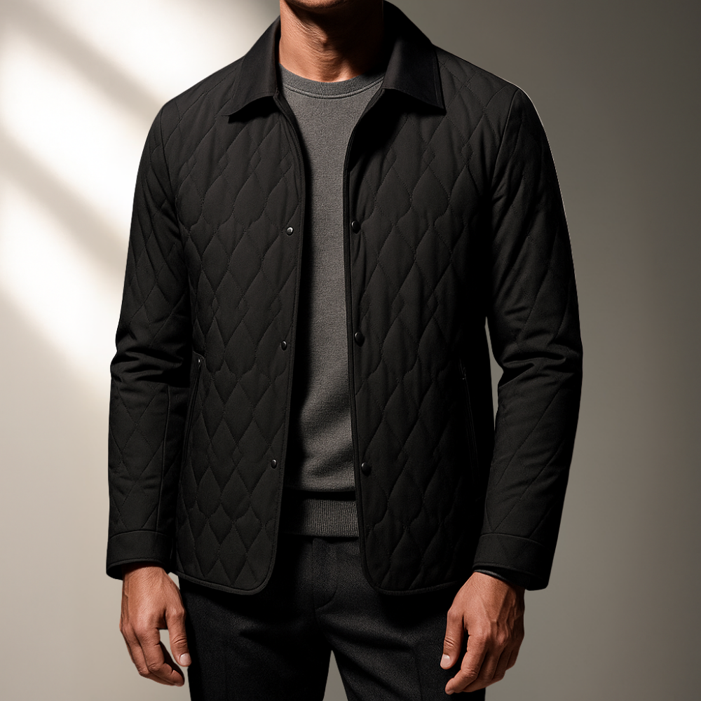 Black diamond-stitch quilted jacket with a turn-down collar and button front, worn over a grey sweater.