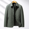 Sage green quilted jacket with diamond-stitch pattern, turn-down collar, and button-front closure on a wooden hanger.