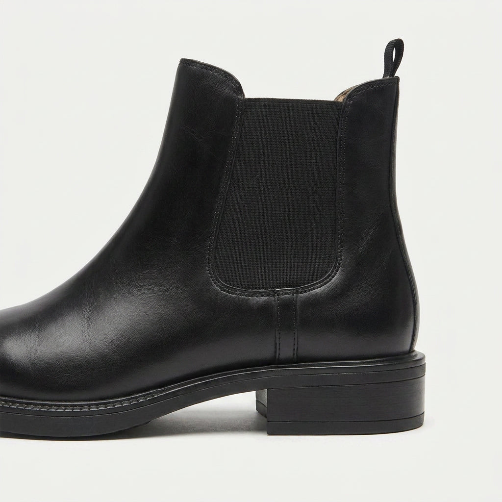 Black vegan leather Chelsea boots with elastic side panels, a rear pull tab, and a low stacked heel.
