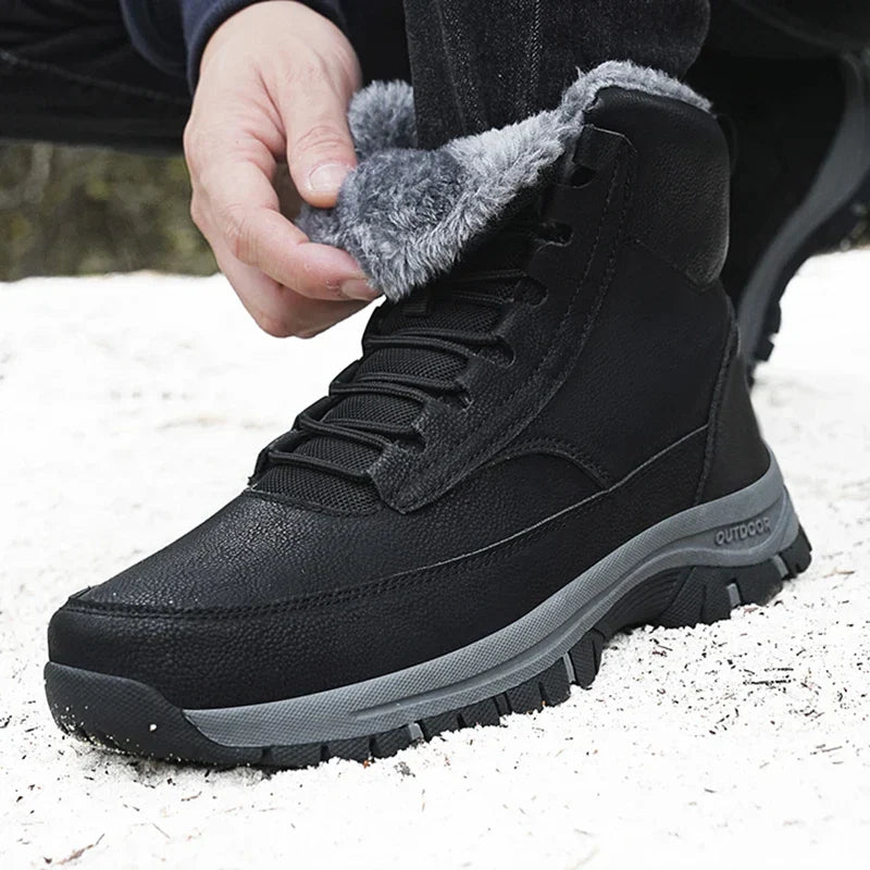 Man folding back the fur collar of a black fleece-lined ankle boot in the snow