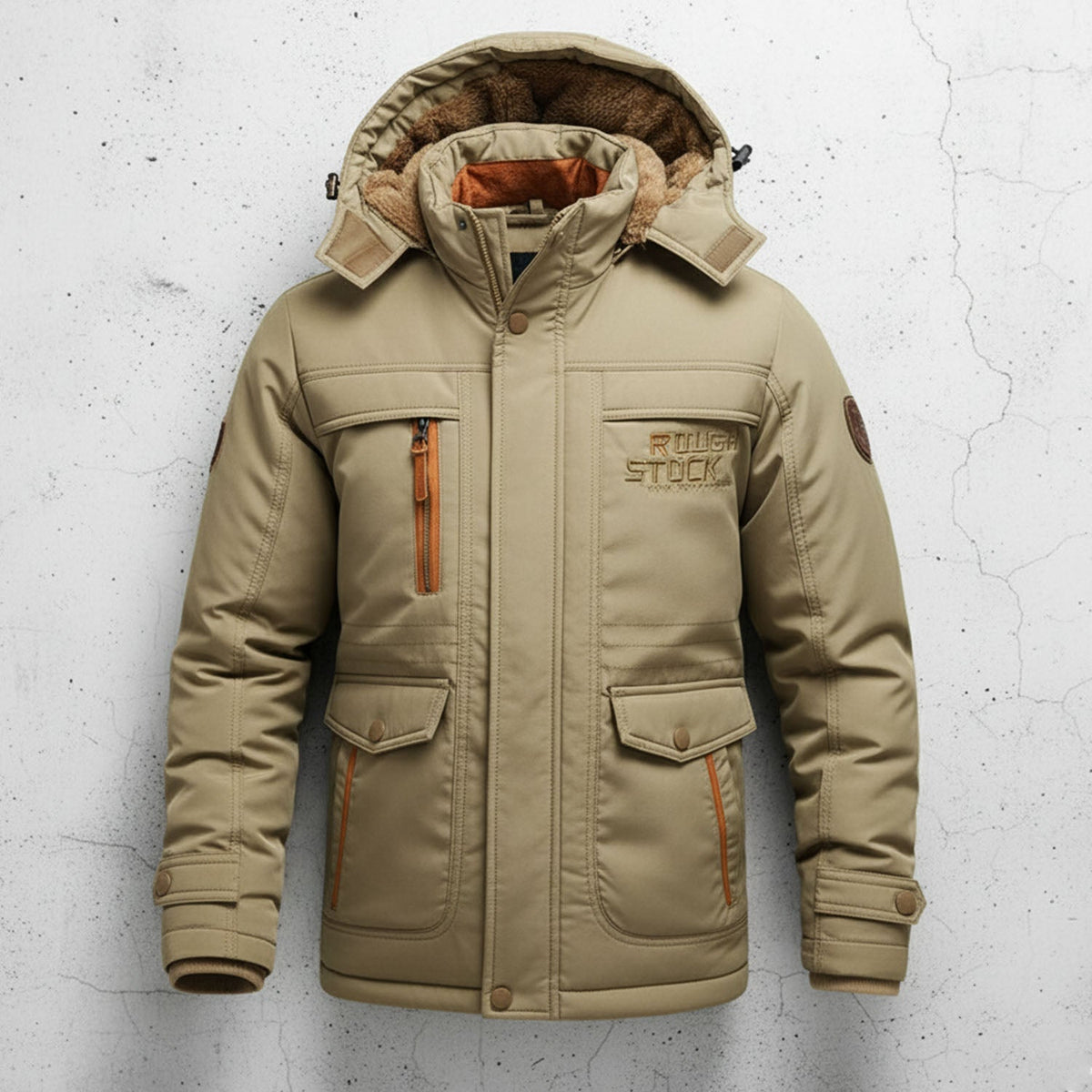 Khaki fleece-lined utility jacket with a detachable hood, contrast zip details, and multiple cargo pockets on a textured wall.