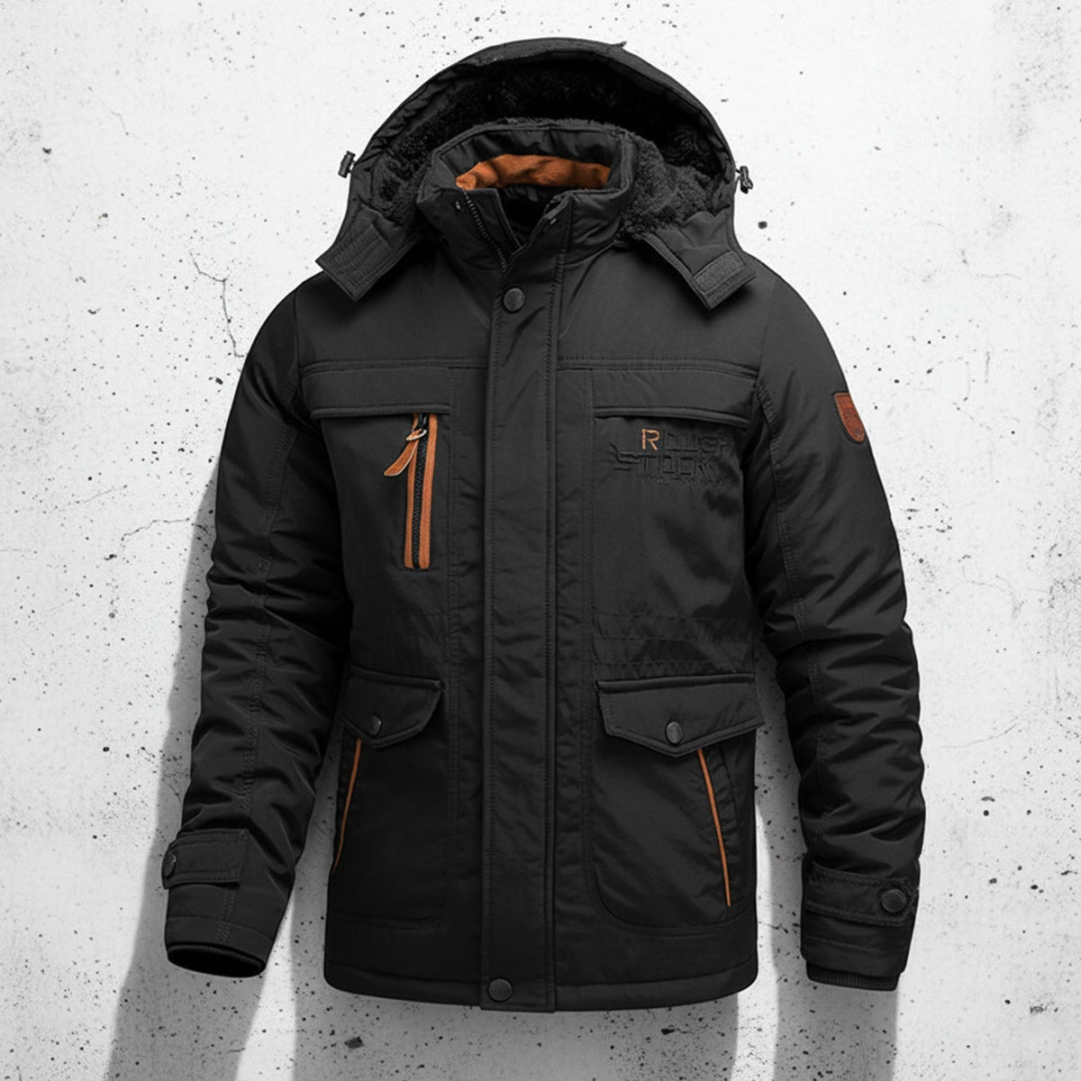 Black fleece-lined utility jacket with a detachable hood, contrast zip details, and multiple cargo pockets on a textured wall.