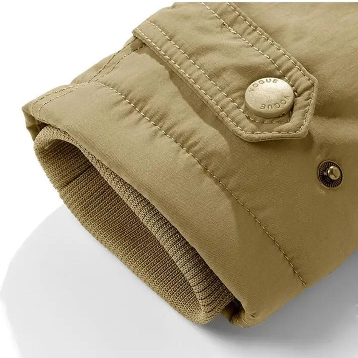 Khaki utility jacket sleeve featuring an adjustable button cuff tab, reinforced stitching, and a ribbed knit inner cuff.