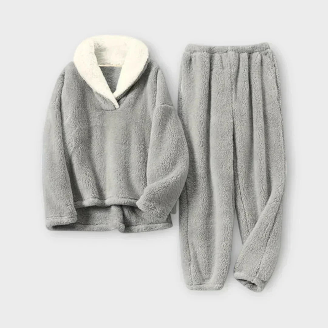 Product flat-lay view of a light gray fleece lounge set featuring a long-sleeve plush pullover with a off-white contrast sherpa lapel collar and matching elastic-waist fleece joggers.