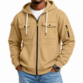 Camel full-zip utility hoodie worn by a male model, featuring snap-flap chest pockets, zippered sleeve pockets, drawstrings, and brushed fleece.