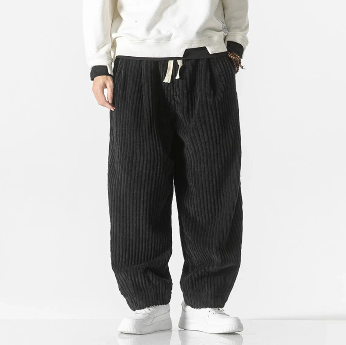 Black gathered-cuff corduroy pants with wide legs and slash pockets