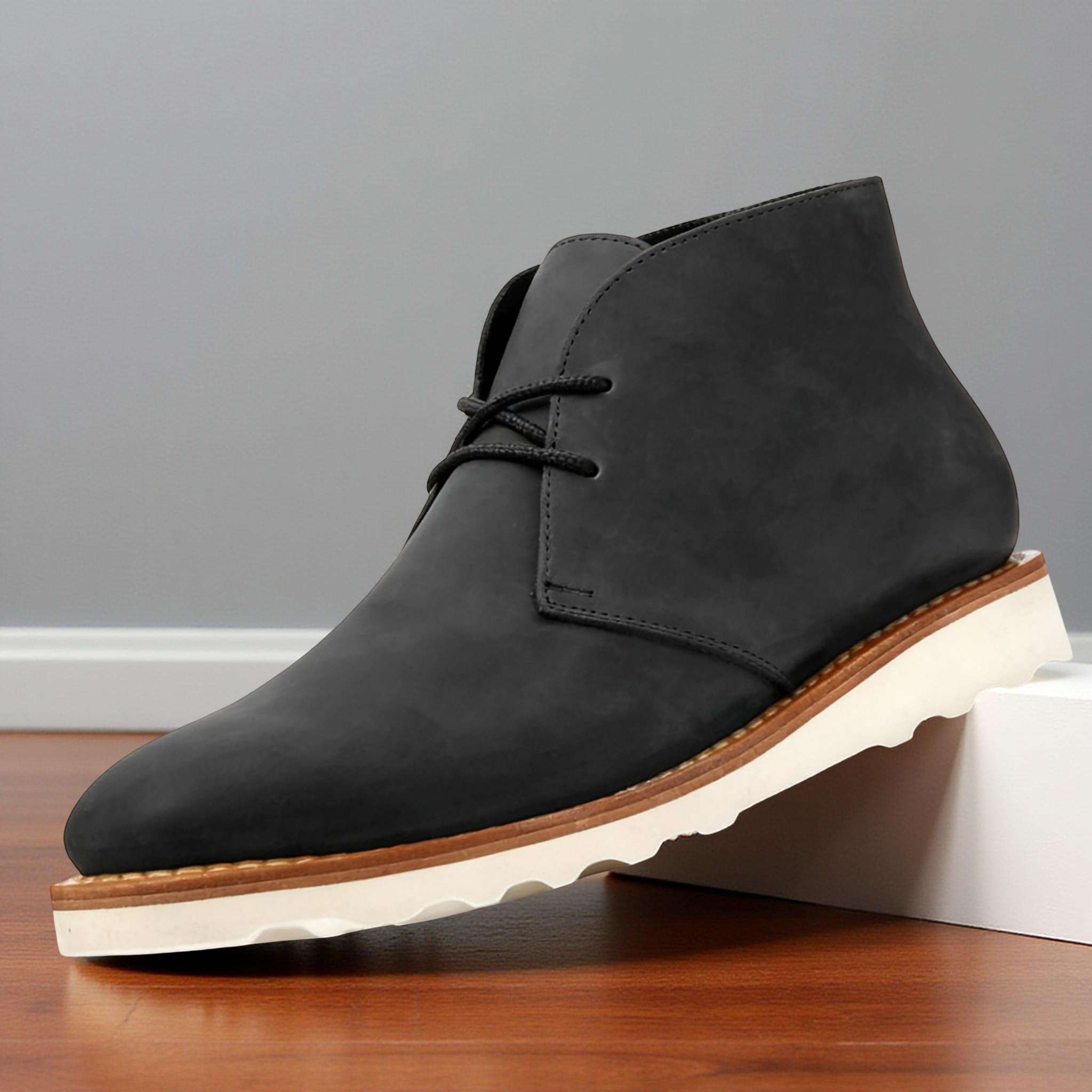 Matte black napped chukka boots with a two-eyelet lace-up front, rounded toe, and a thick, white treaded rubber outsole.