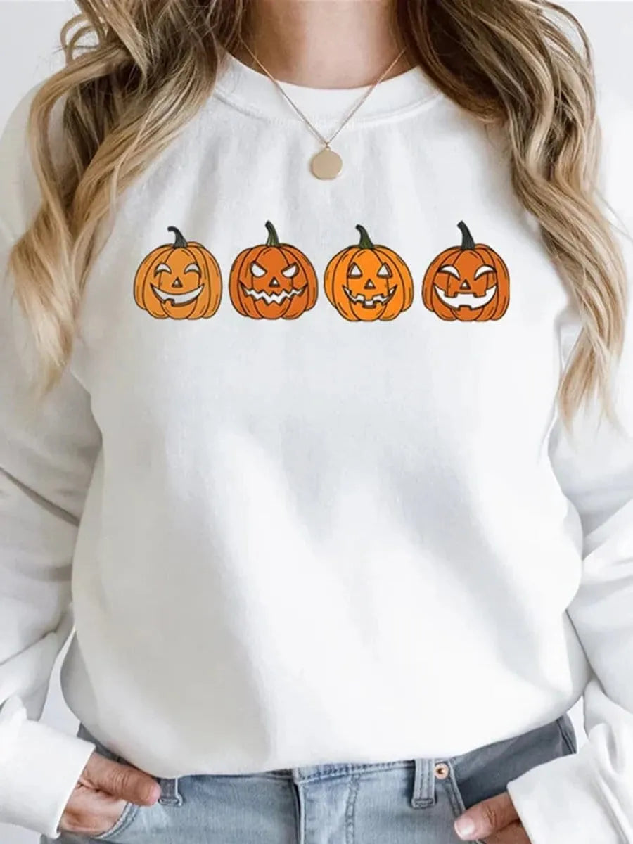 Front view of a model wearing the white Halloween crewneck sweatshirt with the four-pumpkin graphic print across the chest.   