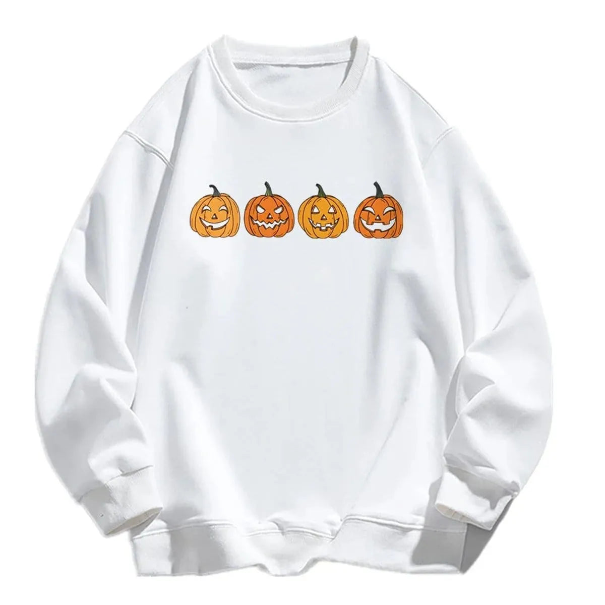Product flat-lay view of a crisp white relaxed crewneck sweatshirt featuring a row of four distinct orange carved jack-o'-lantern pumpkin graphic faces printed across the chest.