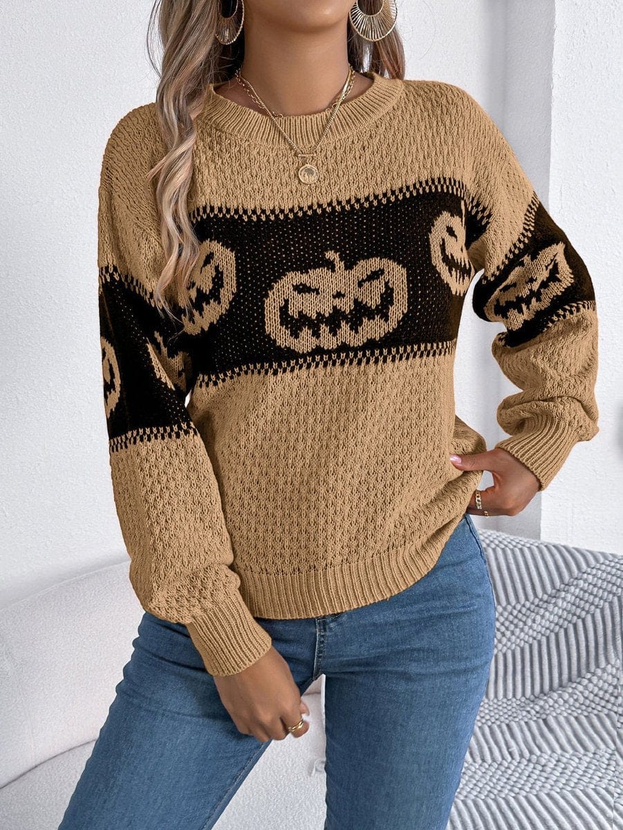 Model wearing the textured knit Halloween pumpkin sweater in warm khaki tan with a black jack-o'-lantern chest band.