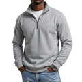 Light gray quarter-zip fleece sweatshirt with a stand collar and long sleeves, paired with blue jeans for a casual everyday look.