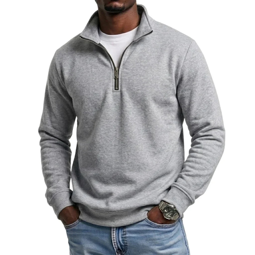 Light gray quarter-zip fleece sweatshirt with a stand collar and long sleeves, paired with blue jeans for a casual everyday look.