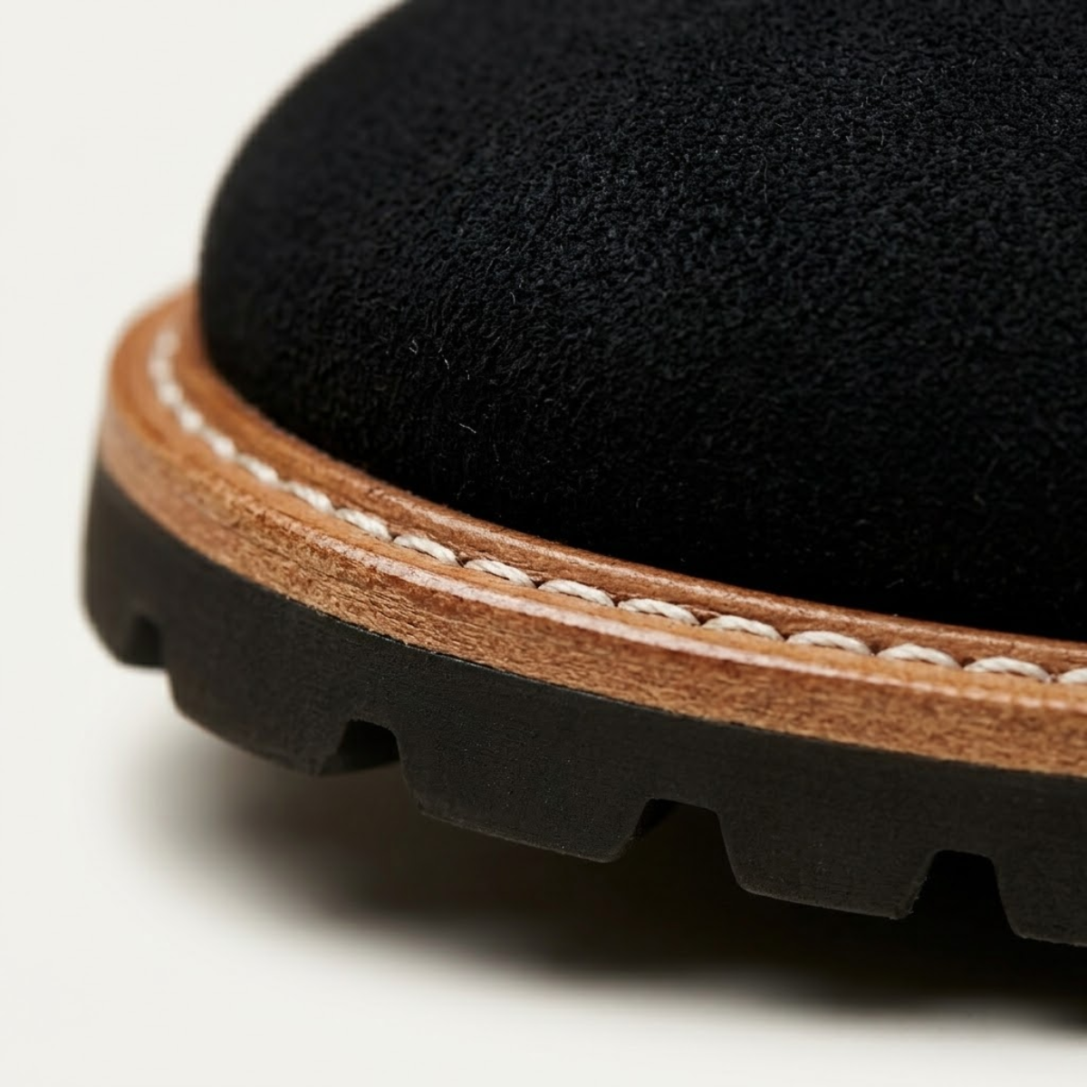 Black suede chukka boot featuring a plain toe, light-toned stitched welt, and a durable black lug tread outsole.