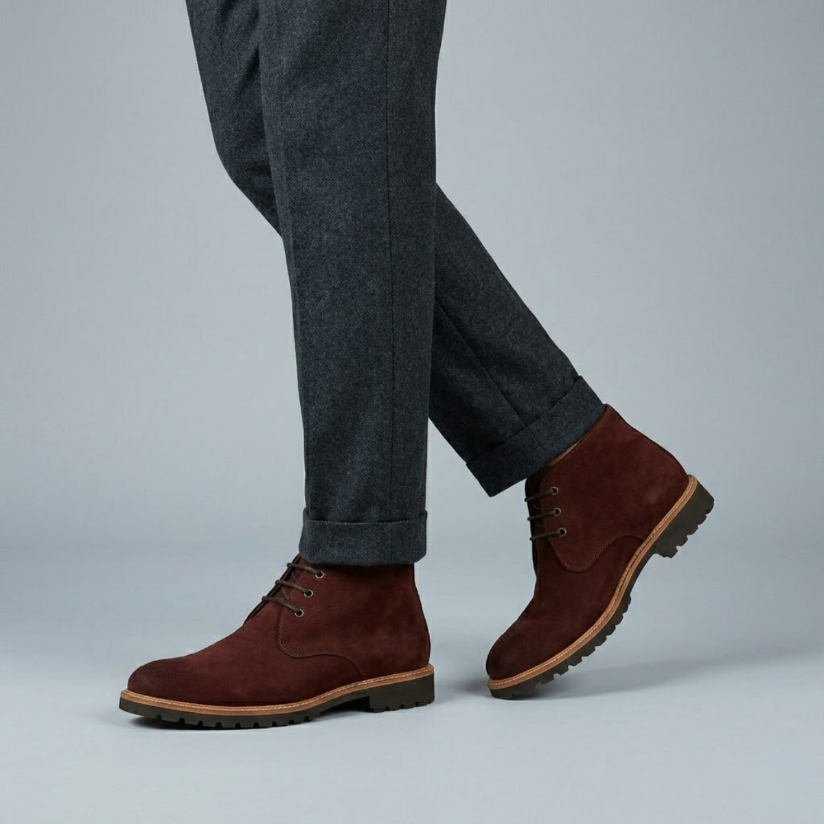 Brown suede chukka boots featuring a three-eyelet lace-up design, plain toe, and a durable lug tread outsole.
