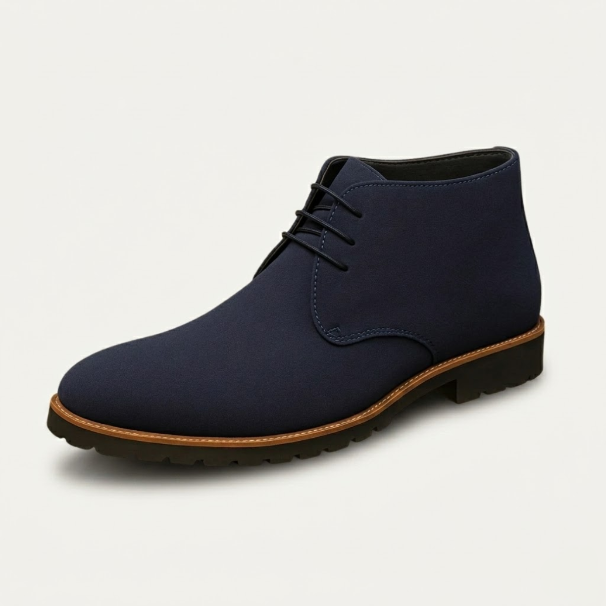 Navy suede chukka boots featuring a three-eyelet lace-up design, plain toe, and a durable lug tread with a stitched welt.