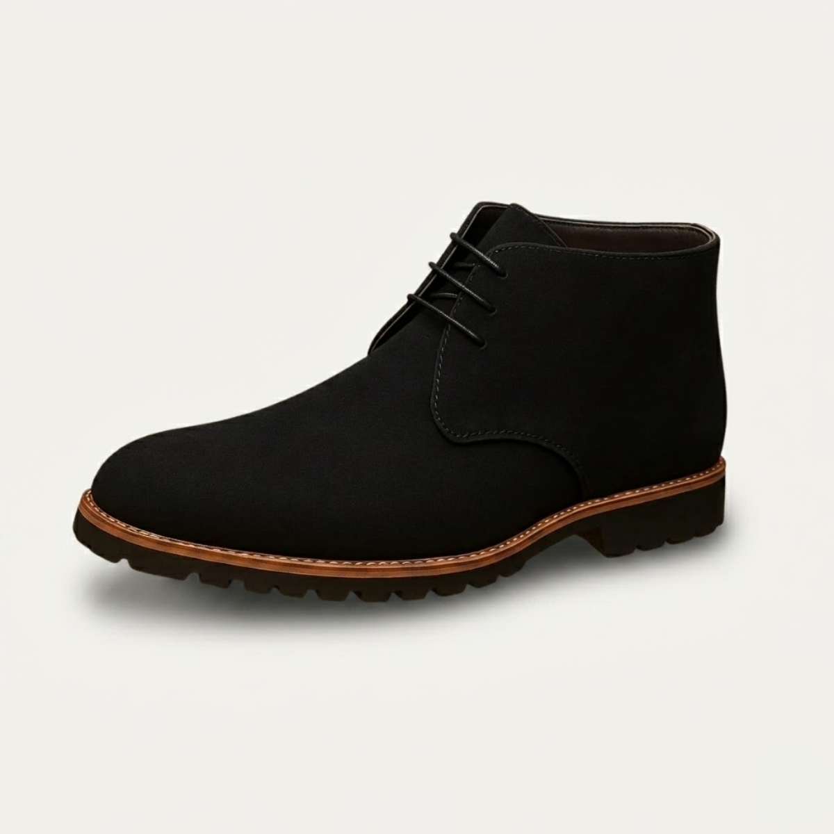 Black suede chukka boots featuring a three-eyelet lace-up design, plain toe, and a sturdy lug tread with a stitched welt.