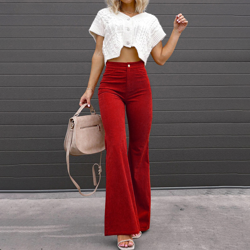 Red high-waisted corduroy flare pants with a fitted thigh, button-zip fly, and ribbed texture worn with a cropped top.