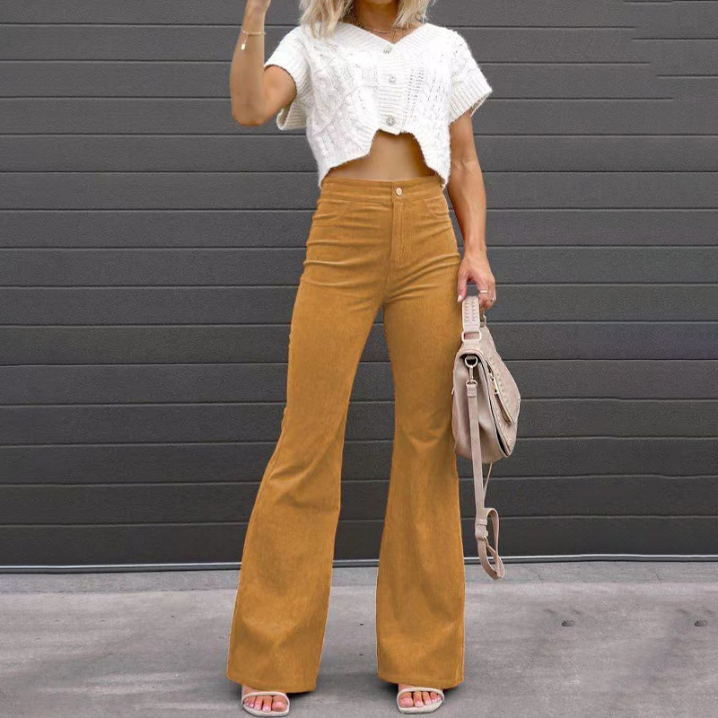 High-waisted mustard corduroy flare pants with a fitted thigh, button-zip fly, and ribbed texture styled with a cropped knit.