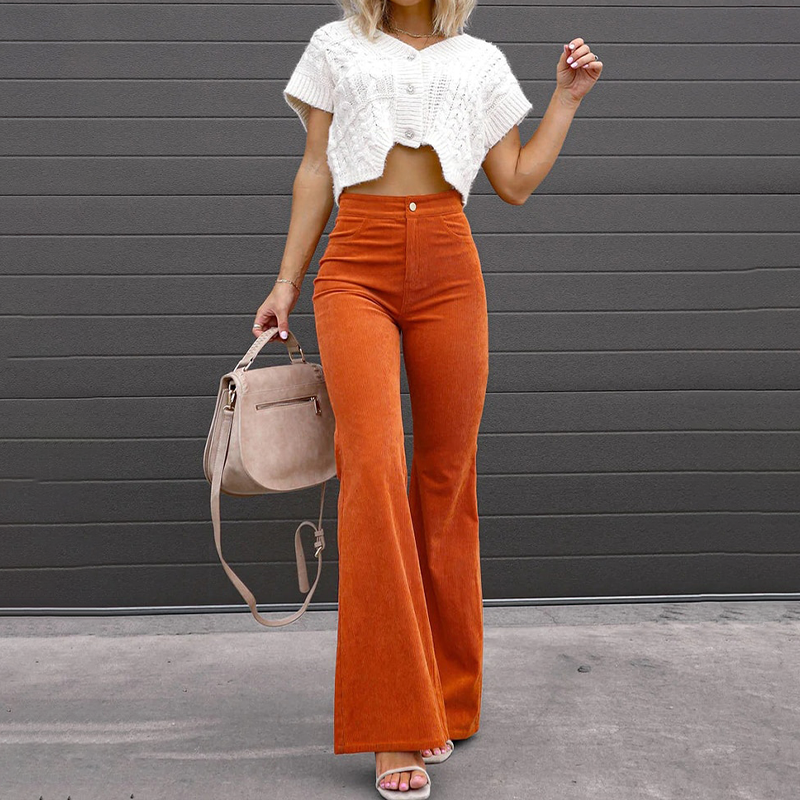High-waisted orange corduroy flare pants with a fitted thigh and button-zip fly, styled with a cropped white knit top.