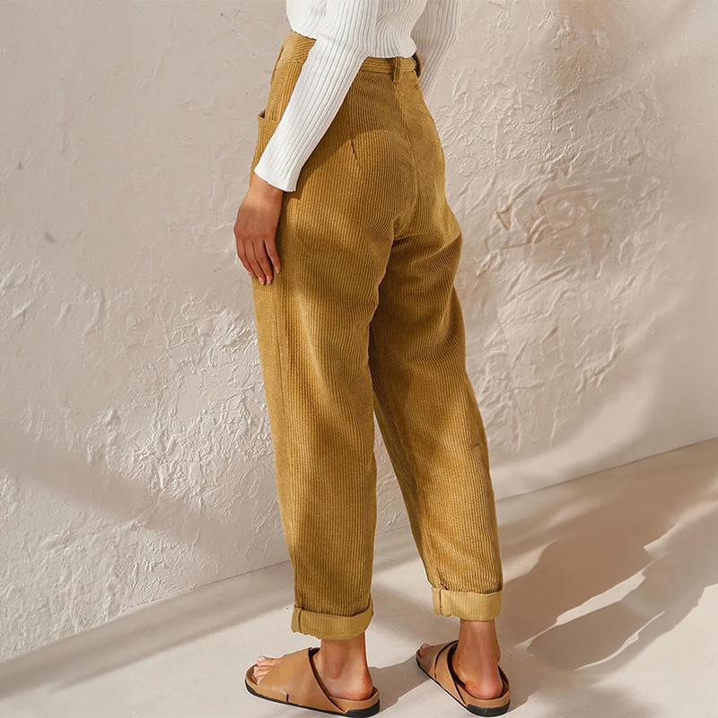 High-waisted mustard corduroy pants with a relaxed tapered leg and adjustable turn-up cuffs in a textured ribbed fabric.