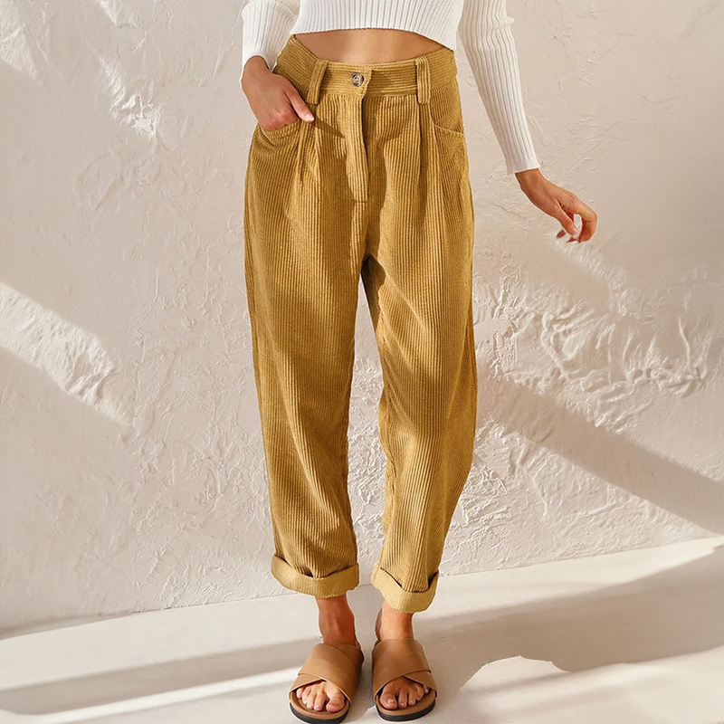 Mustard yellow high-waisted corduroy pants with front pleats, a relaxed tapered leg, and adjustable turn-up cuffs.