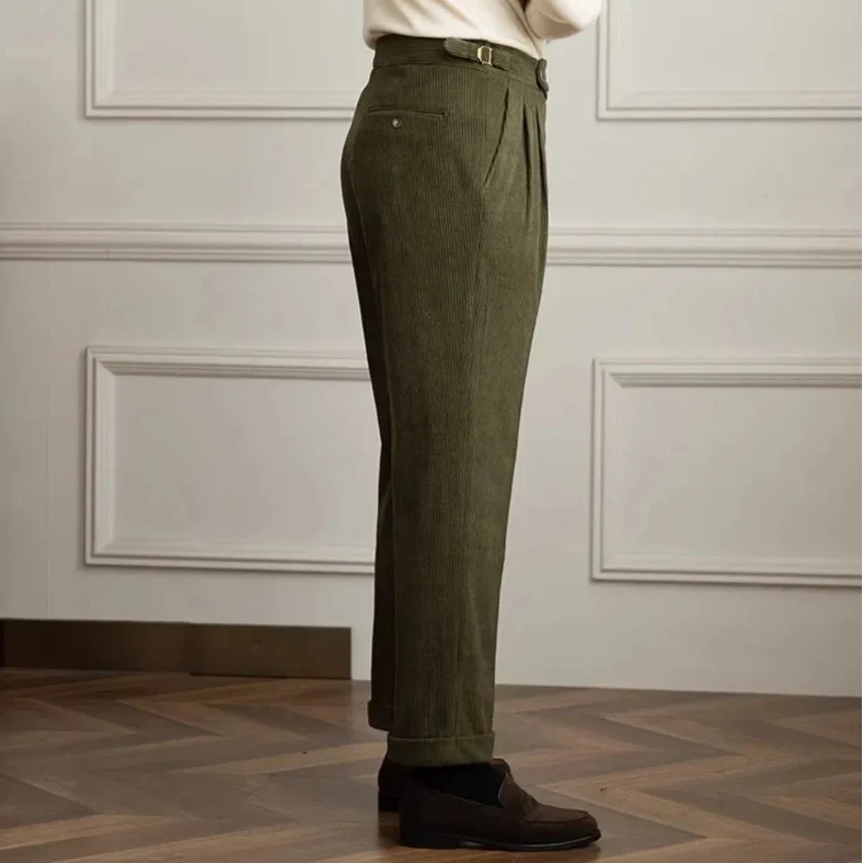 Olive green corduroy pants shown from the side with turn-up cuffs