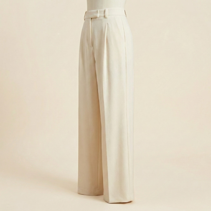 Side three-quarter view on a mannequin of off-white cream high-waisted wide-leg wool dress pants showcasing the relaxed silhouette and front pleat detail.   