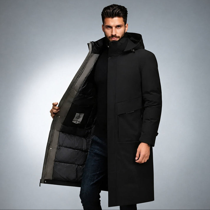 Black longline parka with a matte shell, hooded collar, snap storm flap, and quilted interior lining.