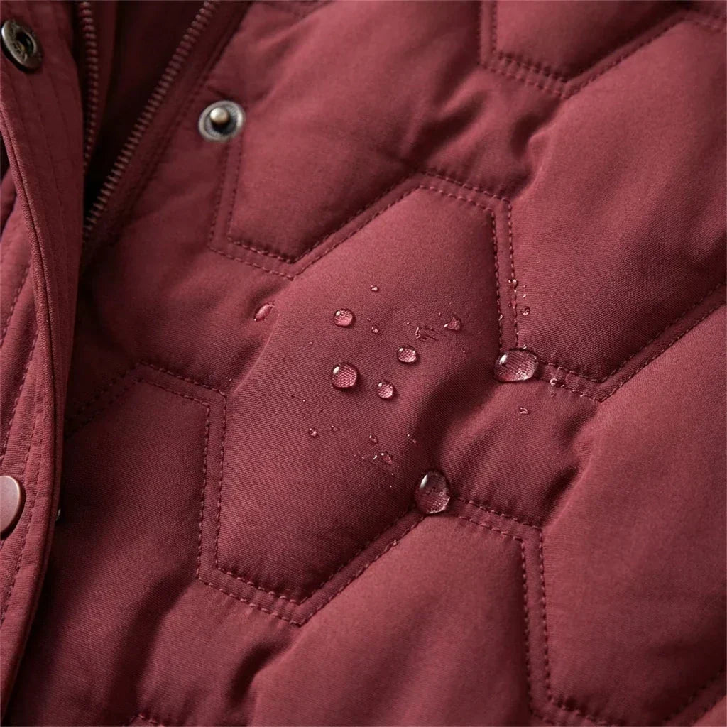 Deep burgundy longline puffer coat with water-resistant finish and geometric quilted stitching detail.