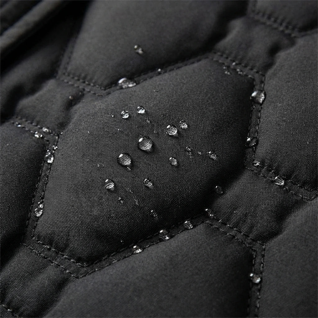 Black quilted puffer fabric with a water-resistant finish and visible moisture droplets on the insulated surface.