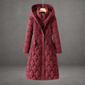 Burgundy longline puffer coat with a hooded collar, insulated geometric quilting, and front snap-button pockets.