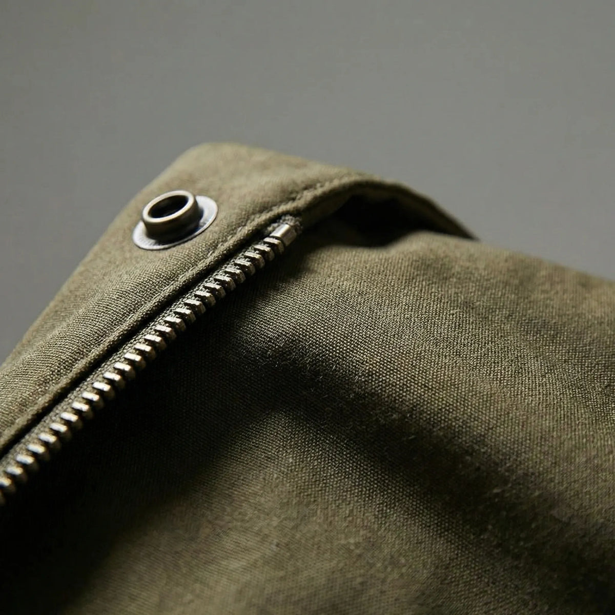 Close-up of the Hooded Padded Longline Trench Coat showing the zipper, metal eyelet detail, and textured fabric.