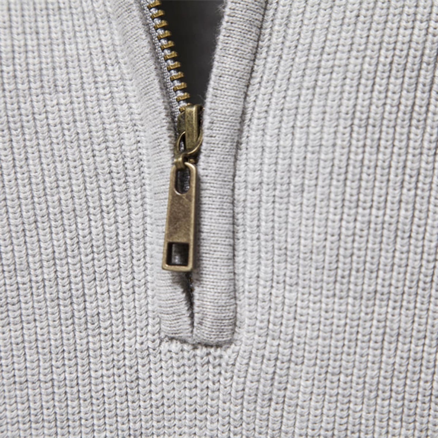Close-up of the quarter-zip collar featuring a metal zipper and finely ribbed knit texture.