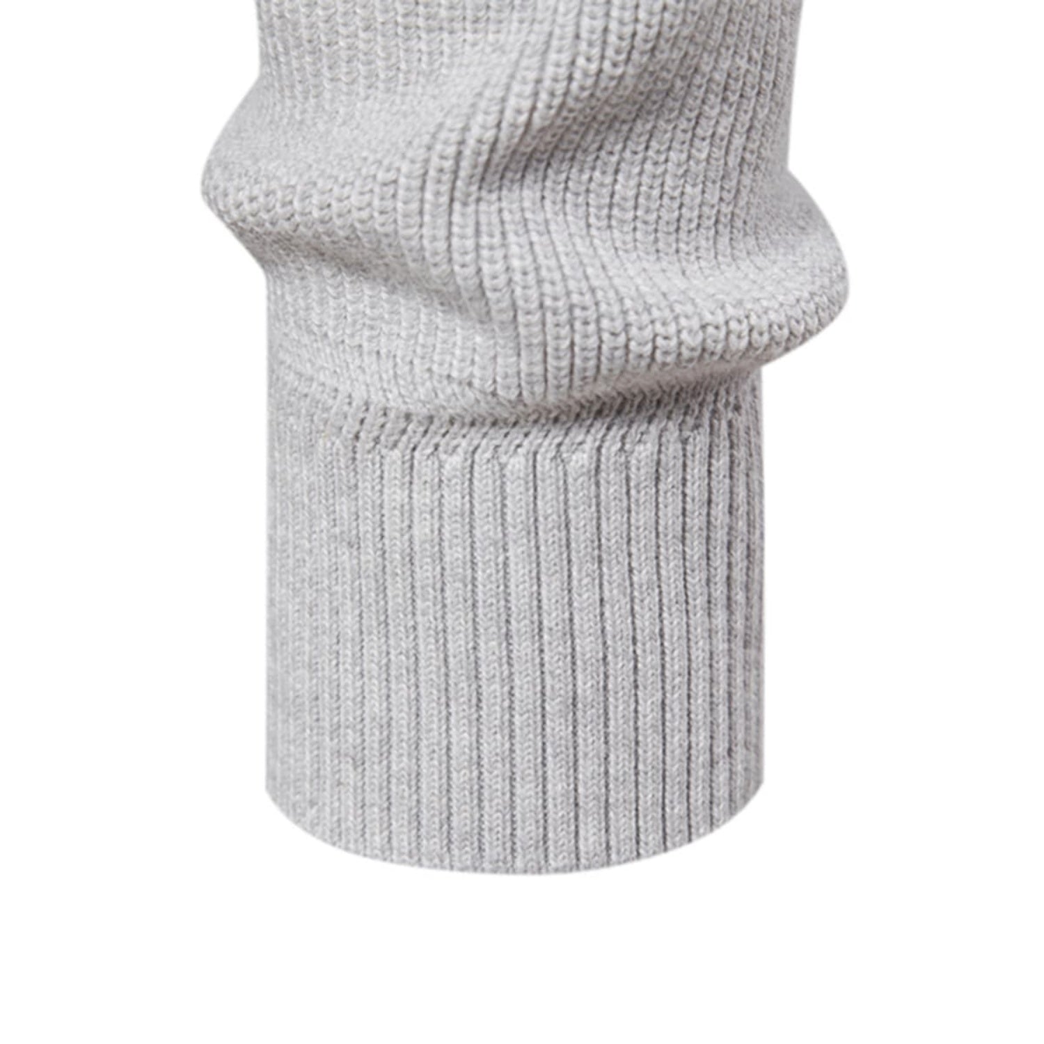 Close-up of the ribbed sleeve cuff and hem of the light gray knit quarter-zip sweater.