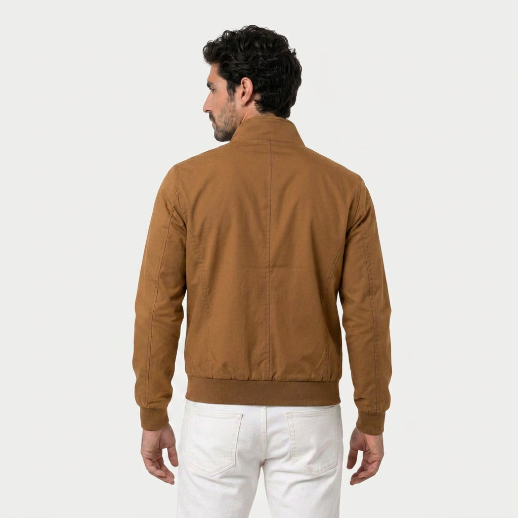 Rear view of a man wearing a camel brown bomber jacket with a stand collar and ribbed hem.
