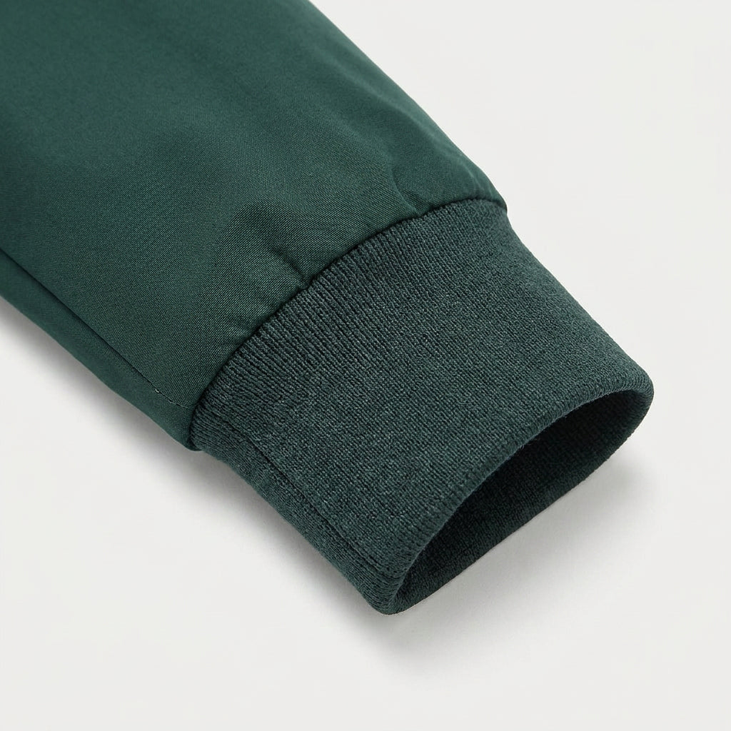 Close-up of the forest green bomber jacket ribbed cuff highlighting the premium fabric and stitching.