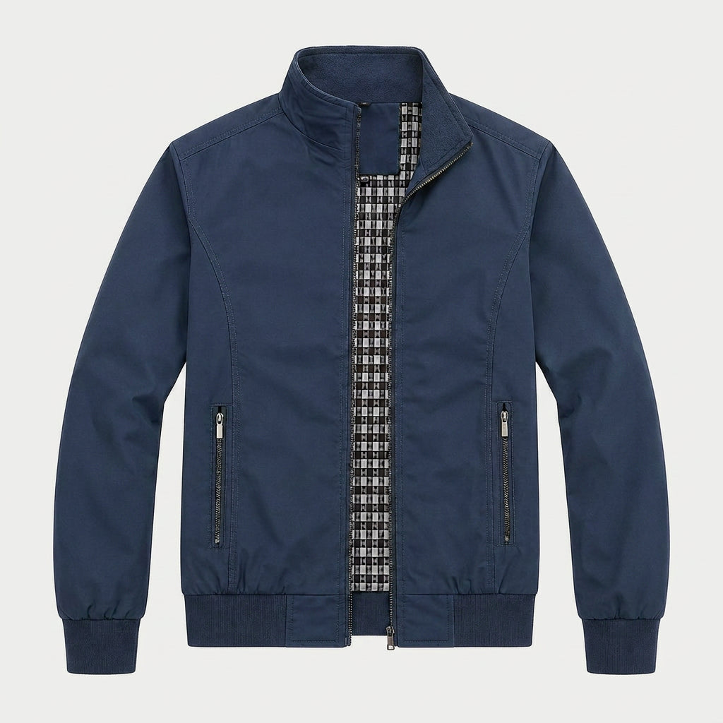 Navy zip-up bomber jacket with a stand collar, plaid lining, zippered pockets, and ribbed cuffs displayed on a white background.