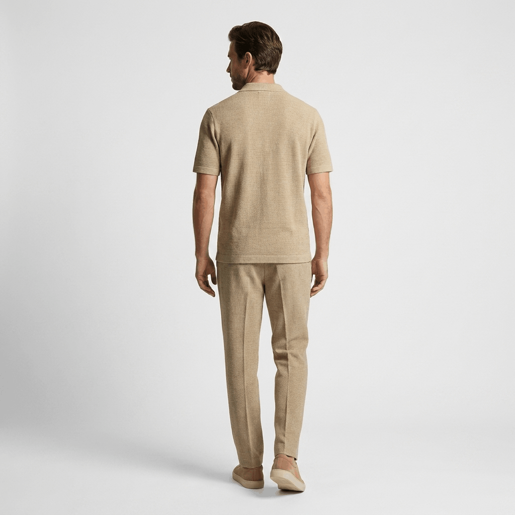 Back view of a man wearing a khaki short-sleeve linen shirt with matching linen trousers.