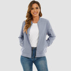 Light blue lightweight bomber jacket in water-resistant polyester with ribbed trim, zip sleeve pocket, and relaxed fit.