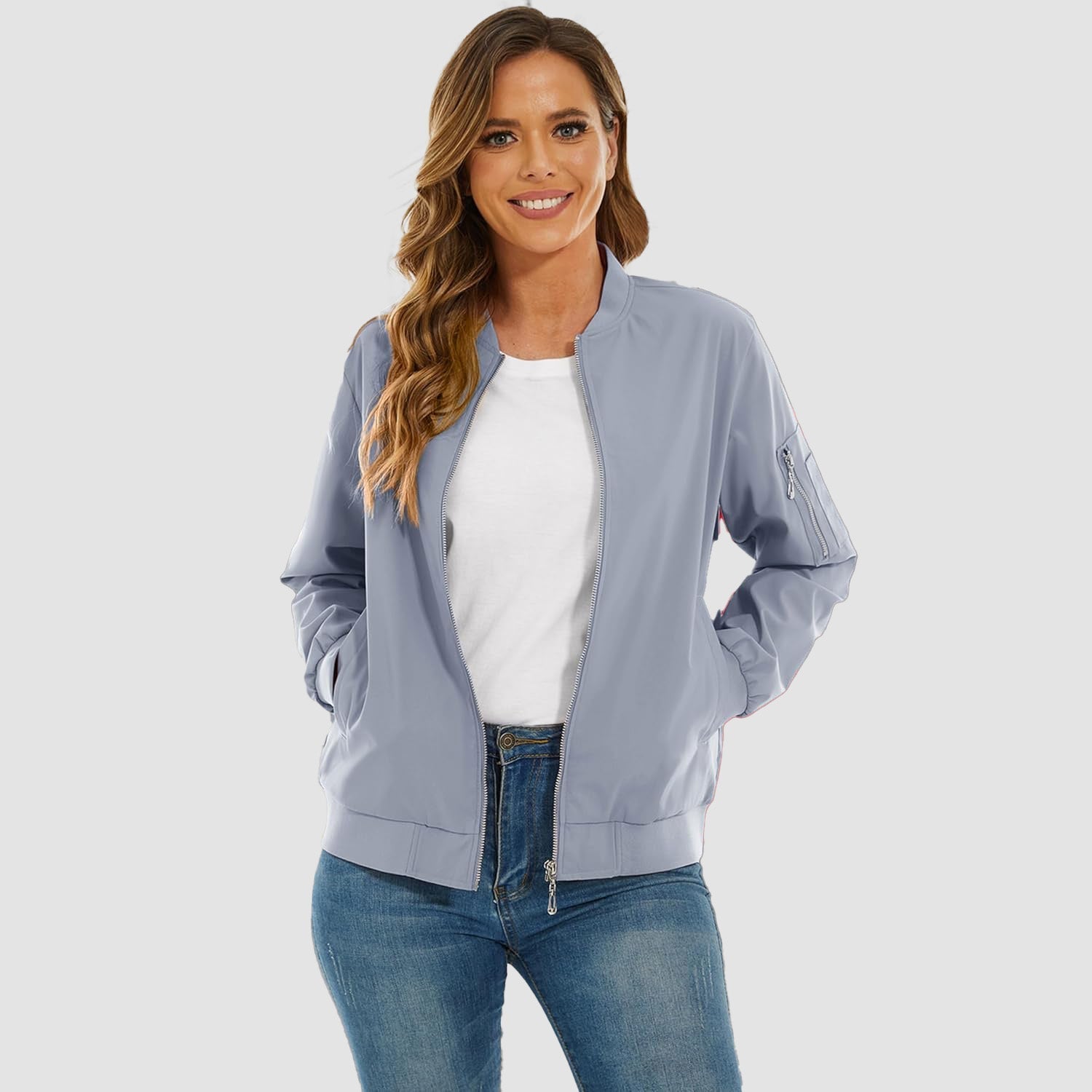 Light blue lightweight bomber jacket in water-resistant polyester with ribbed trim, zip sleeve pocket, and relaxed fit.