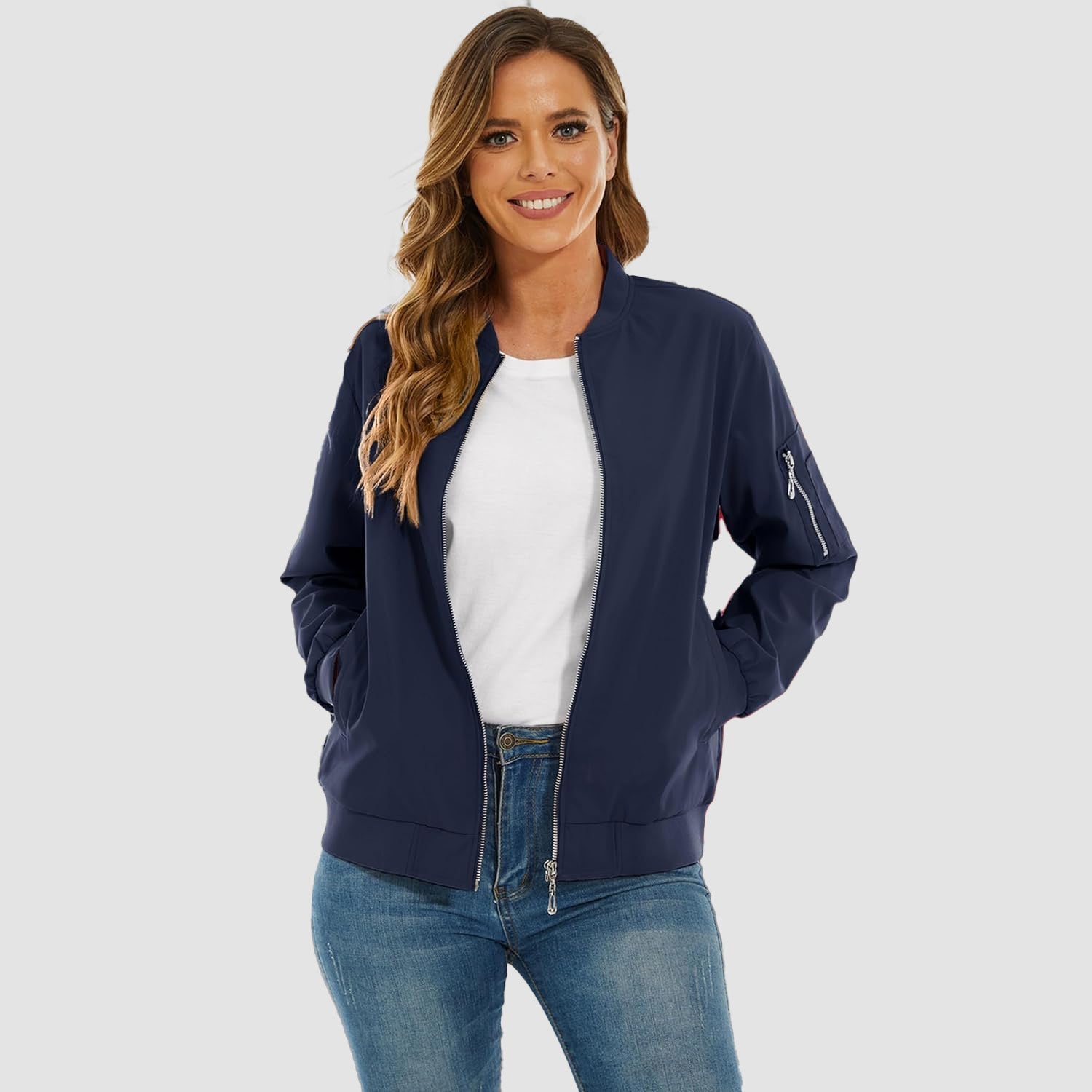 Navy blue lightweight bomber jacket with a zip-up front, ribbed trim, and utility sleeve pocket worn over a white tee.