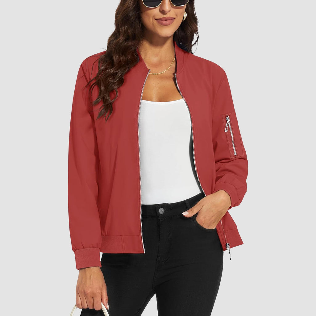 Red lightweight bomber jacket in water-resistant polyester with a zip sleeve pocket and ribbed trim, worn over a white top.