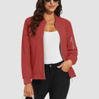 Red lightweight bomber jacket in water-resistant polyester with a zip sleeve pocket and ribbed trim, worn over a white top.